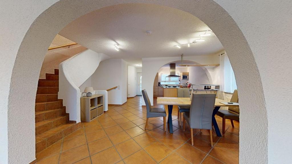 a dining room and kitchen with a table and chairs at Ferienhaus Hoffmann am Rheinbogen in Altlußheim