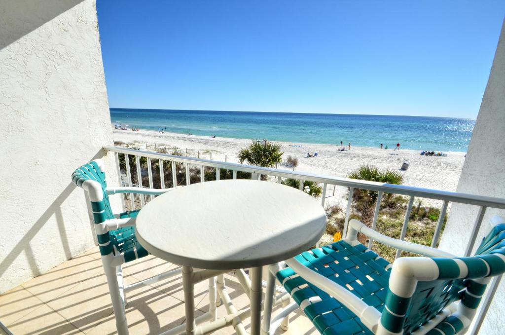 balkon ze stołem i krzesłami oraz plażą w obiekcie Blue Haven Villa w mieście Panama City Beach