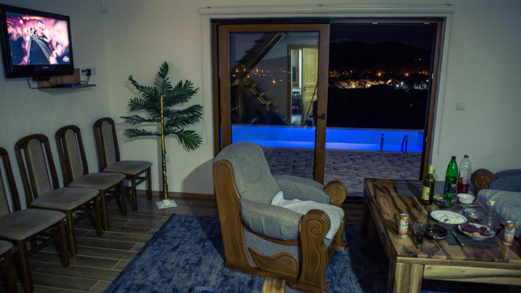 a living room with a table and chairs and a television at Zivinice Hills in Živinice