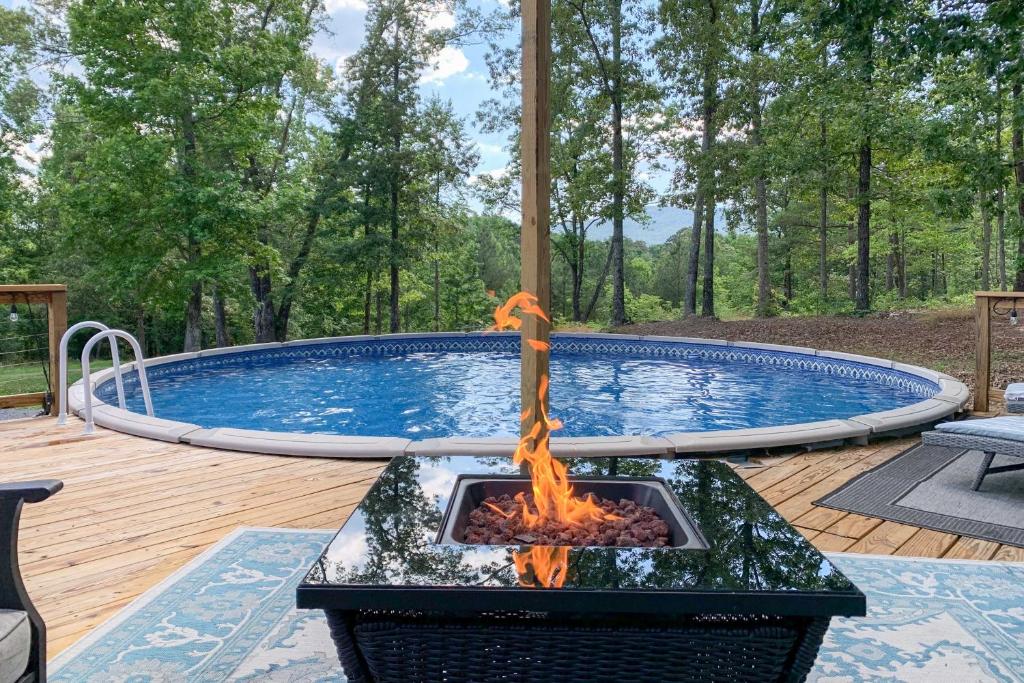 uma fogueira em frente a uma piscina em Charming Cottage with Hot Tub 15 Mi to Chattanooga! em Chickamauga