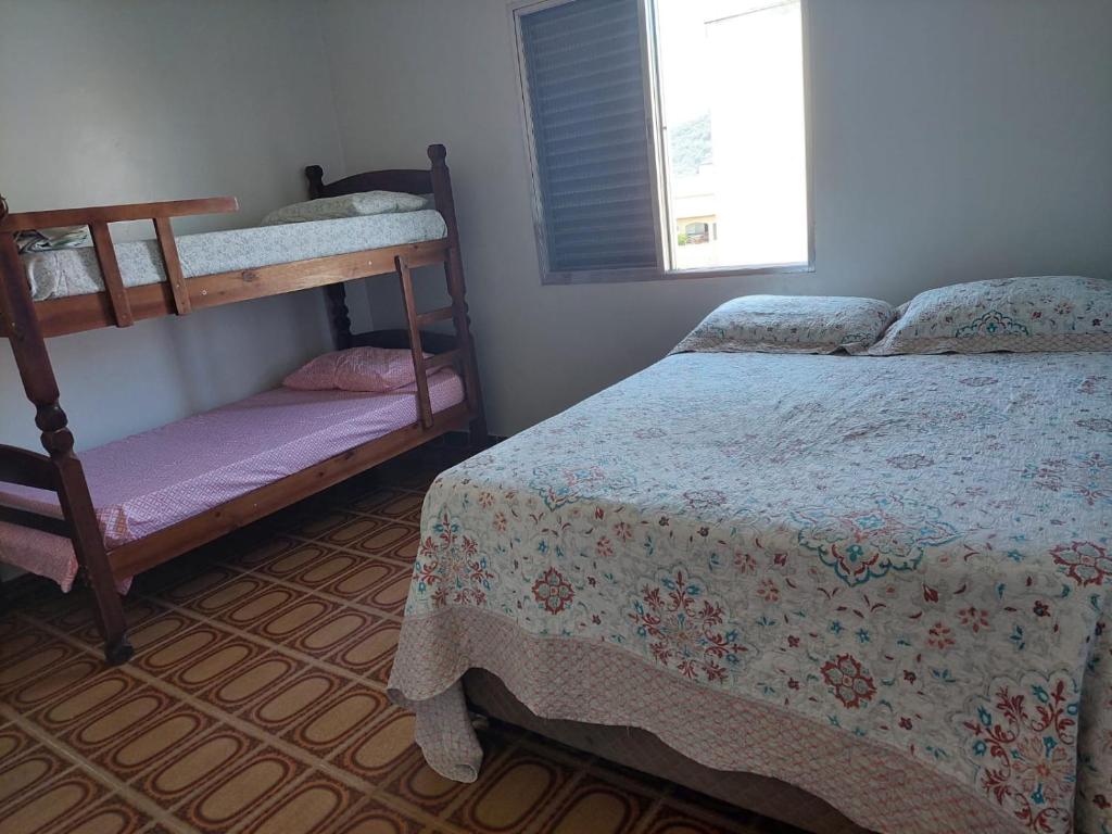 a bedroom with two bunk beds and a window at Apartamento Brisa Do Mar em Peruíbe in Peruíbe