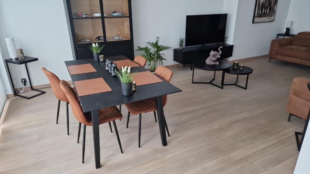 a dining room with a black table and chairs at Gezellig appartement Beveren-Waas Donkvijver in Beveren