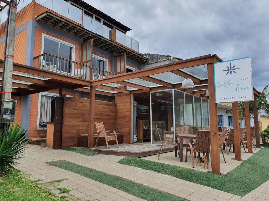 a house with a table and chairs in front of it at Pousada Bella Rosa - Capão da Canoa in Capão da Canoa