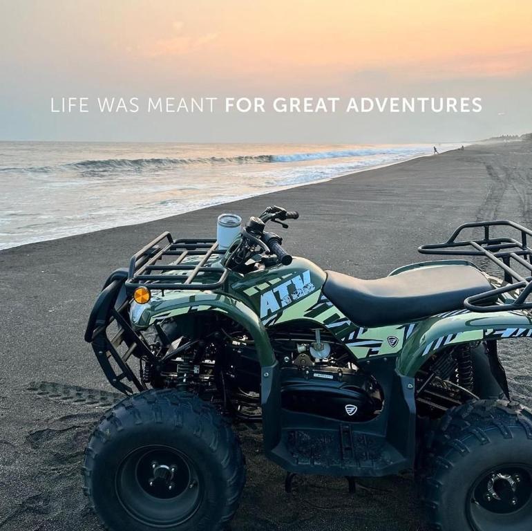 una moto de tierra estacionada en la playa con palabras la vida era para grandes aventuras en Beach House “El Rosario”, en La Candelaria