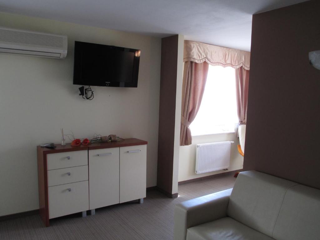 ein Wohnzimmer mit einem Sofa und einem TV an der Wand in der Unterkunft U Szelca in Krosno