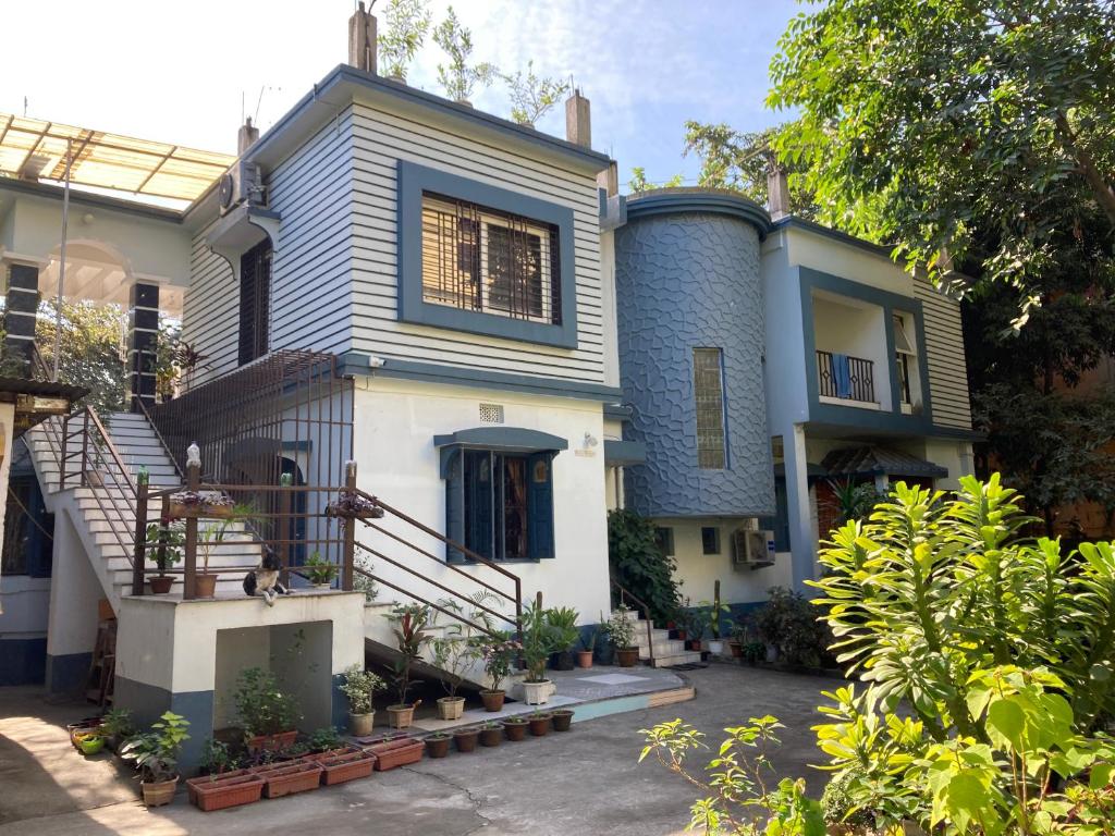 uma casa azul e branca com escadas e plantas em Anjali HOMESTAY em Siliguri