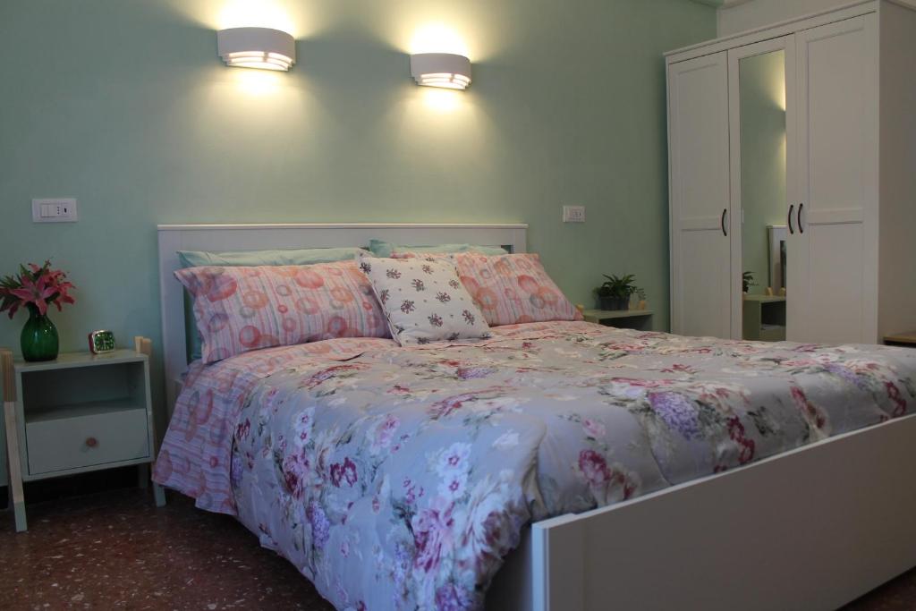 um quarto com uma cama com lençóis e almofadas cor-de-rosa em Holiday Relax em La Spezia