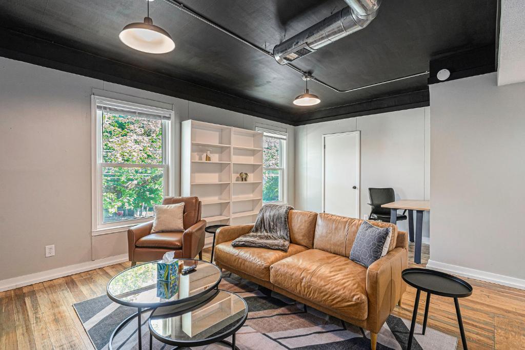 The Loft Life - Modern Corporate Housing في غراند رابيدز: غرفة معيشة مع أريكة وطاولة