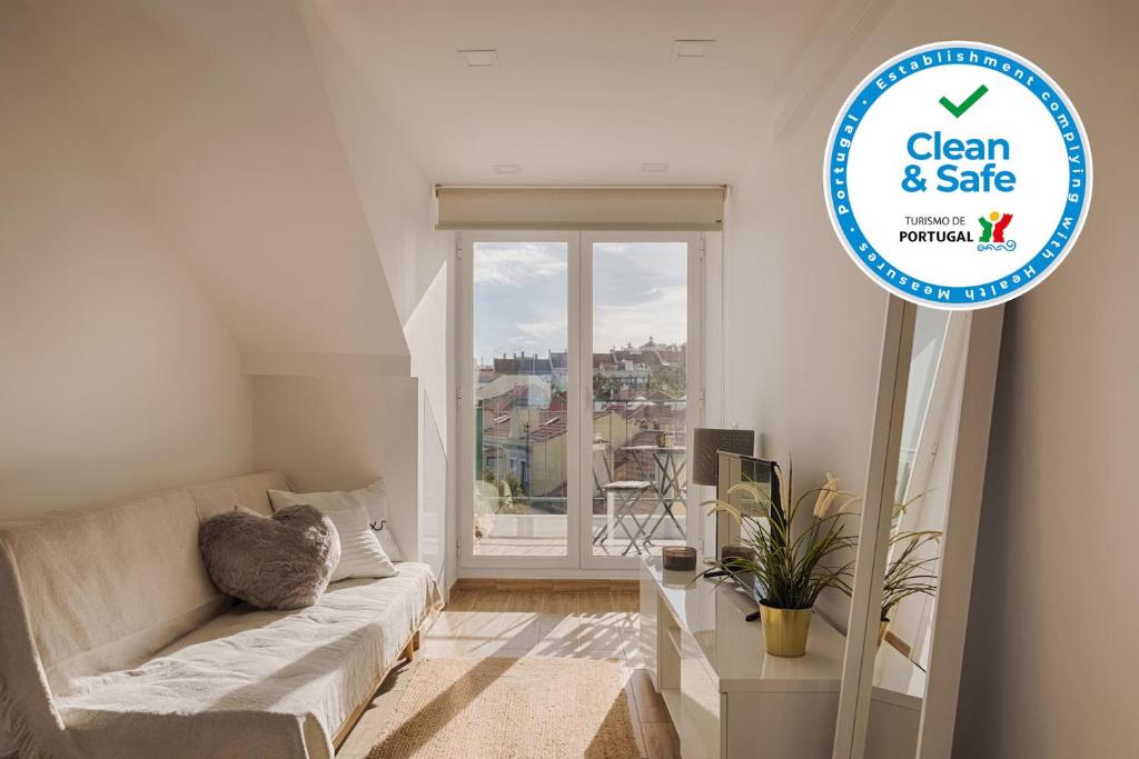 un soggiorno bianco con divano e finestra di Romantic Gem with 2 Terraces in Alcântara a Lisbona