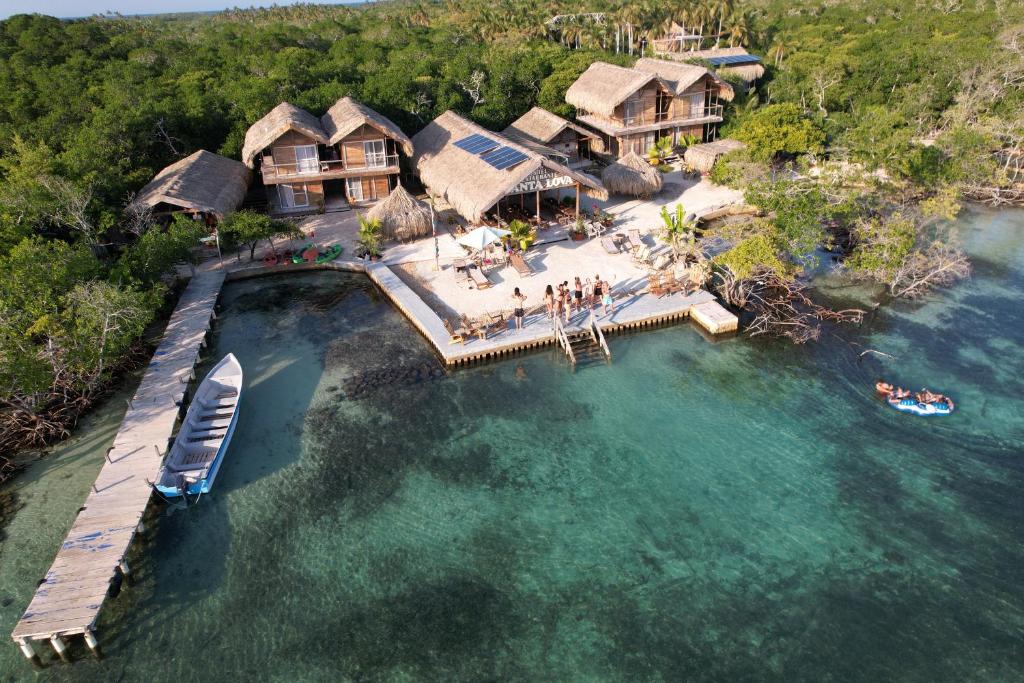 an aerial view of a house on the water with a boat at Santa Lova Eco-hostel Isla Tintipan in Tintipan Island