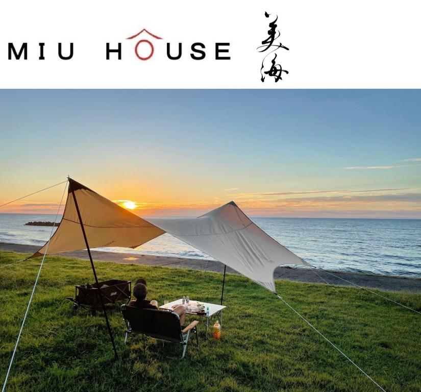 Un uomo seduto su una sedia a guardare il tramonto di MIU HOUSE - Vacation STAY 30561v a Izumo