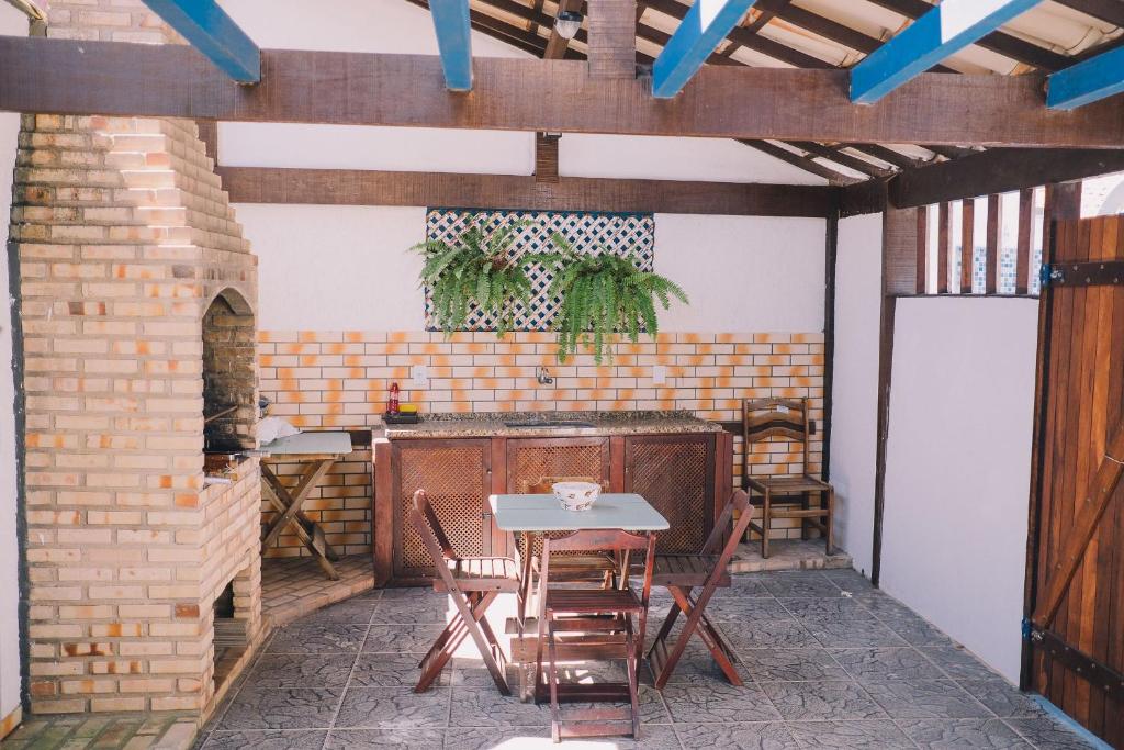 eine Außenterrasse mit einem Tisch und Stühlen in der Unterkunft Casa com churrasqueira e 3 quartos - Centro in Búzios