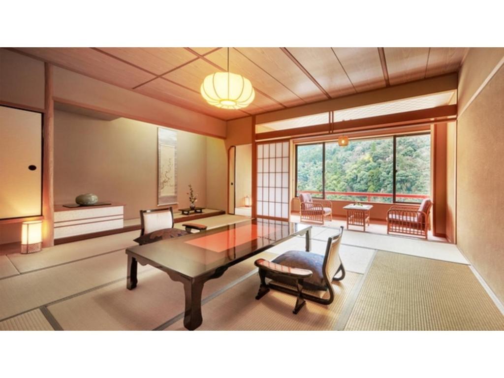 a living room with a table and chairs and a large window at Mansuirou - Vacation STAY 32145v in Misasa