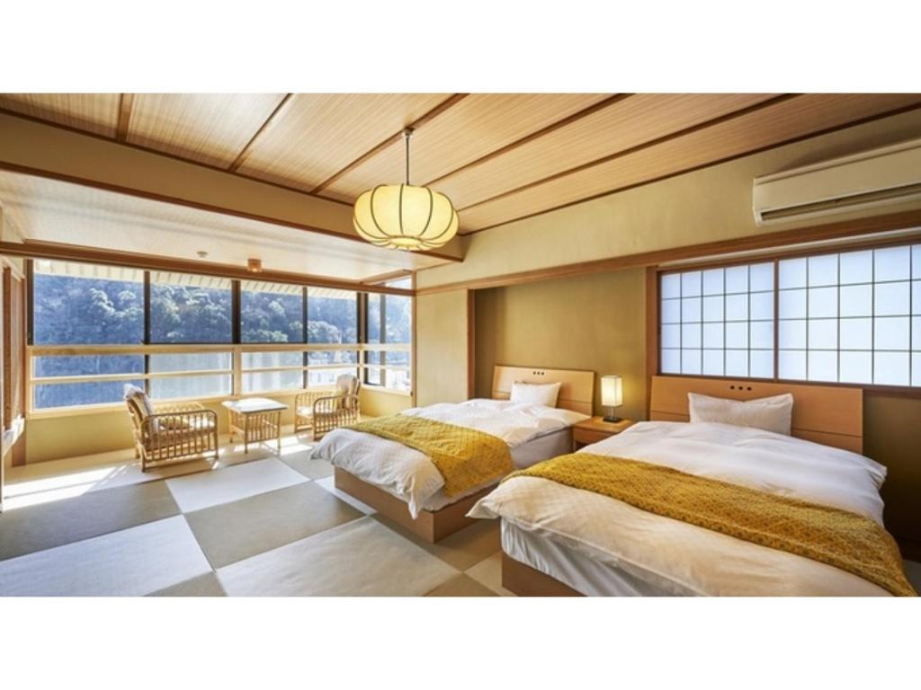 Mansuirou - Vacation STAY 32150v في Misasa: سريرين في غرفة مع نافذة كبيرة