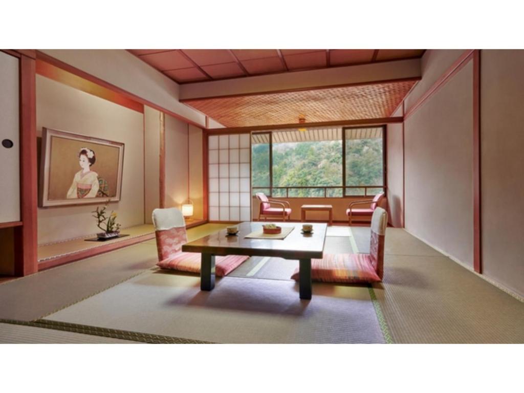 sala de estar con mesa y algunas sillas en Mansuirou - Vacation STAY 32148v, en Misasa