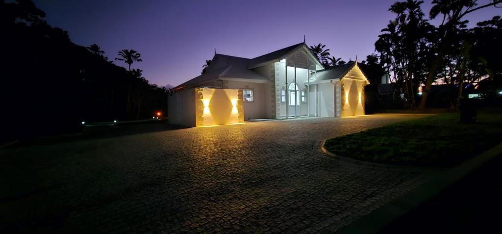 una casa con luci su un vialetto di notte di Caribbean Estates Villa Varie - Brand new Villa - est December 2023! a Port Edward