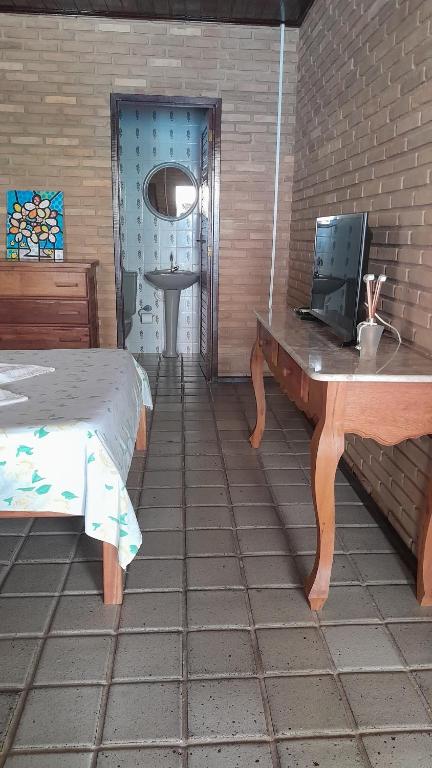 a bedroom with a bed and a desk with a computer on it at Quartos aconchegantes na praia do francês in Marechal Deodoro