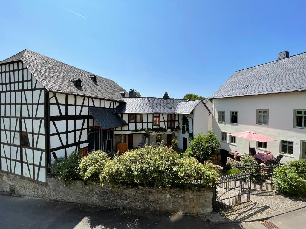 ein altes Haus und ein weißes Gebäude mit einer Terrasse in der Unterkunft Gut Bunt Ferienhaus in Runkel