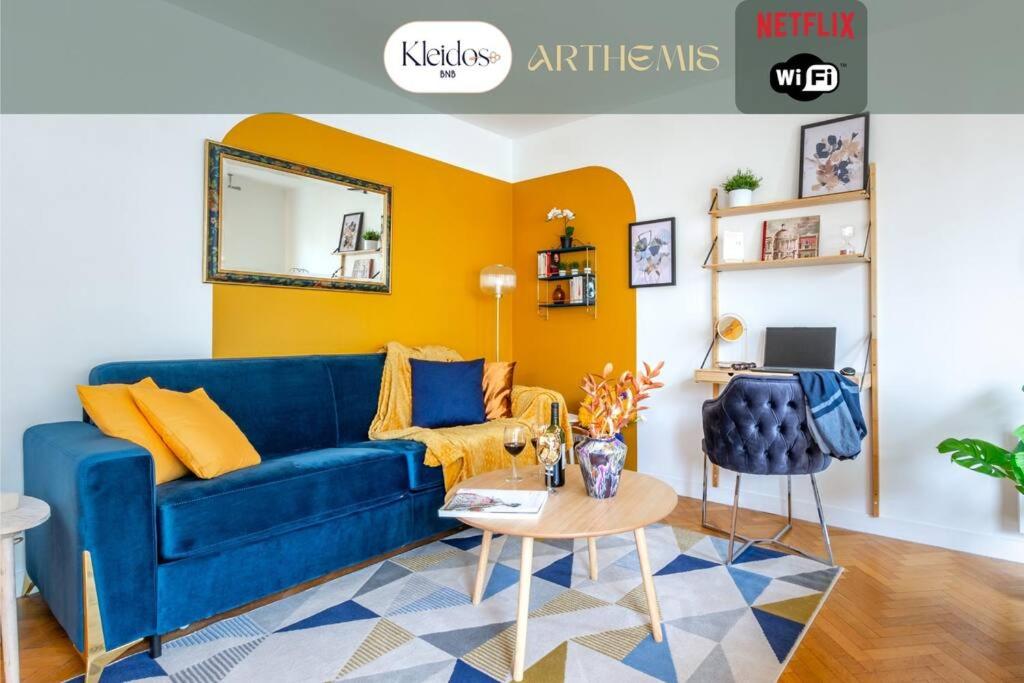 a living room with a blue couch and a table at Artémis-10 min. from Versailles Gardens, parking in Le Chesnay