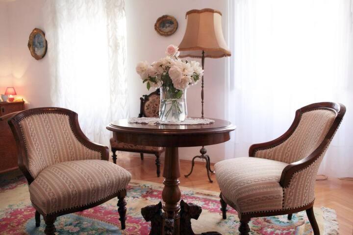 um vaso de flores sobre uma mesa com duas cadeiras em Two bells em Sibenik