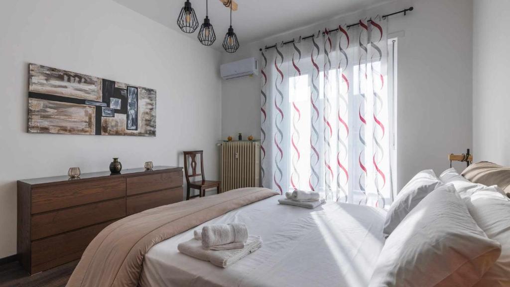 um quarto com uma cama e uma janela com riscas vermelhas em Lingotto Inalpi Arena Luminoso Appartamento em Turim