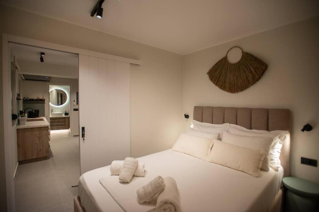 a bedroom with a large white bed with towels on it at YOLO Resort- Giardino in Alykes