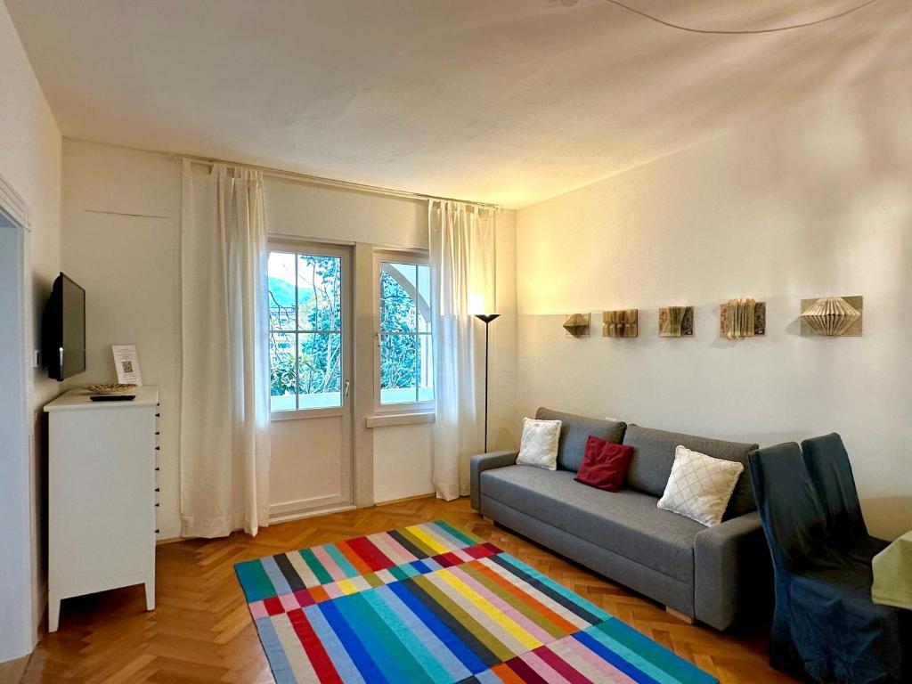 sala de estar con sofá y alfombra colorida en Baker House, en Bolzano