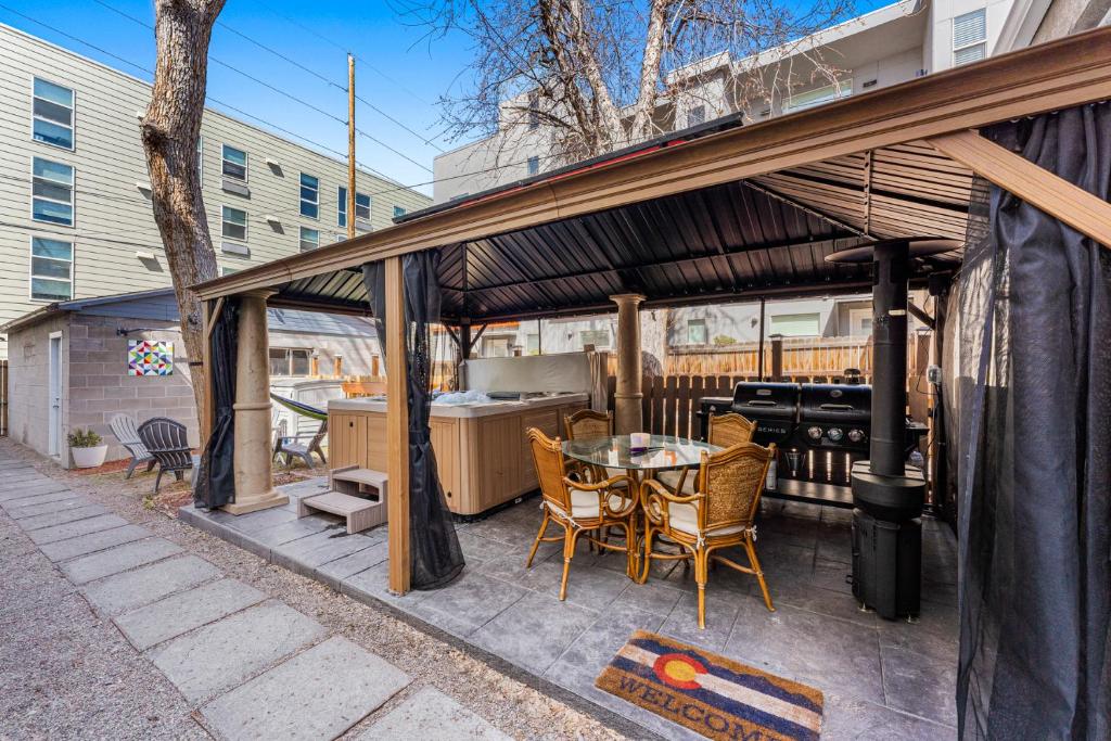 um pátio com uma mesa, cadeiras e comodidades para churrascos em HOT TUB Firepit Pool Table Patio Cozy Downtown Denver em Denver