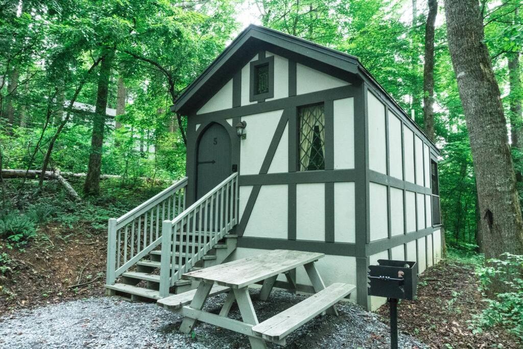 a small black and white play house with a bench at Tiny Home Cottage Near the Smokies #5 Fleur in Sevierville