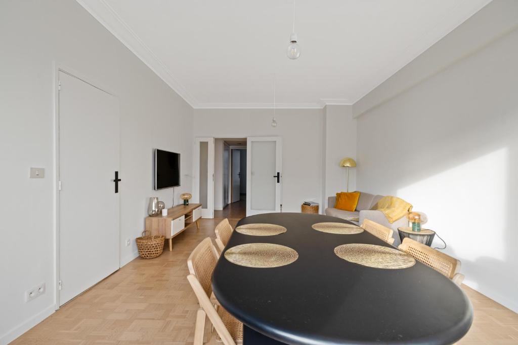 a dining room with a black table and chairs at De Meir & Opera Urban Elegance Apt in Antwerp