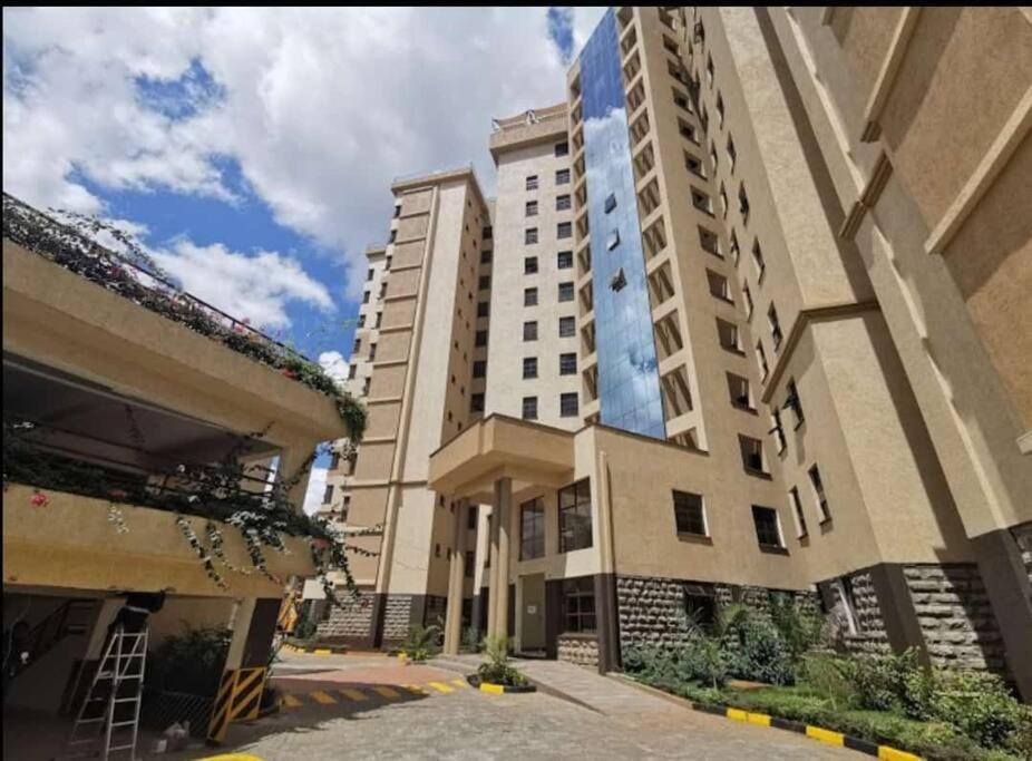 a large white building with two buildings at Madaraka 2 Bed apartment with Rooftop pool. in Nairobi