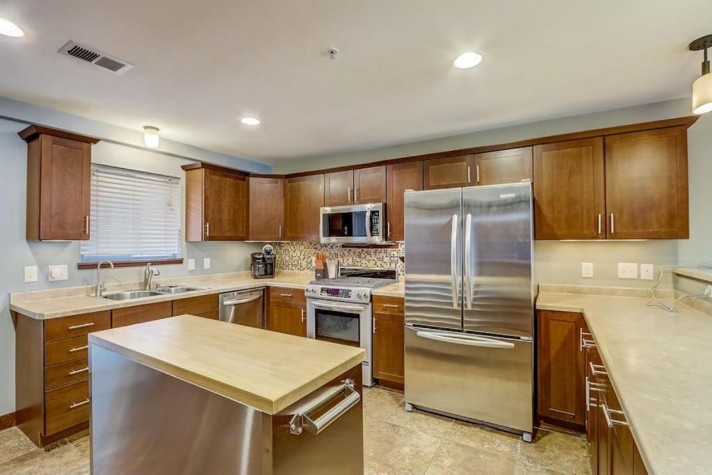 a kitchen with wooden cabinets and a stainless steel refrigerator at WFC IV Adults or Families Lakefront View in Wisconsin Dells