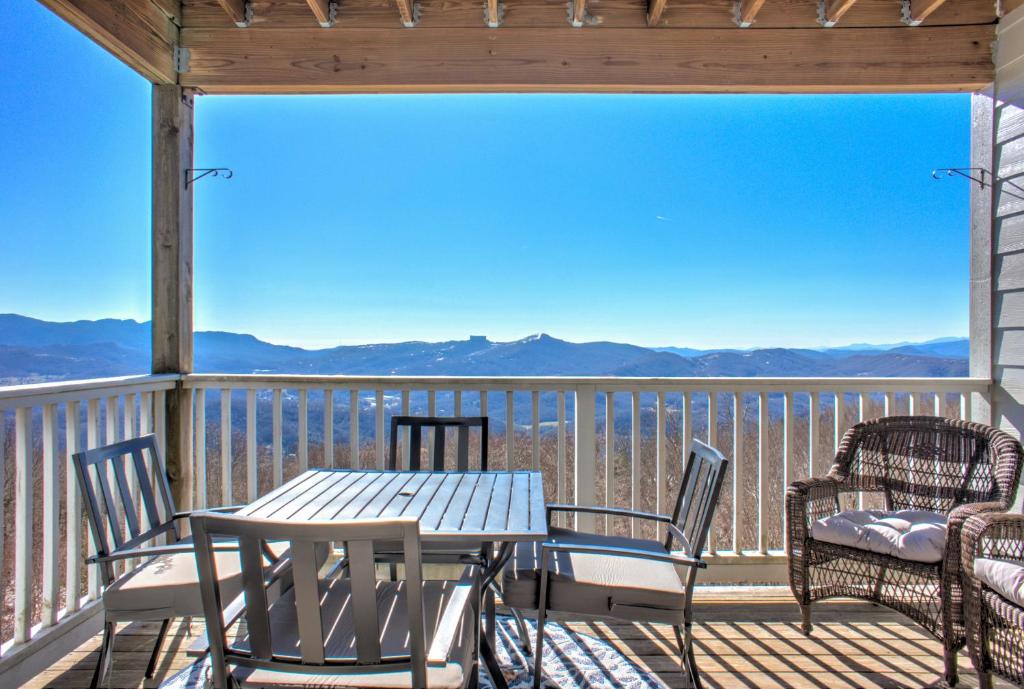 a table and chairs on a deck with a view at Carolina North by VCI Real Estate Services in Beech Mountain