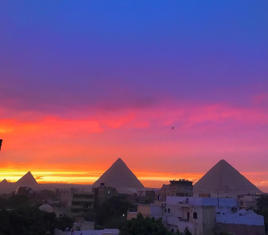 een uitzicht op de piramides van Giza bij zonsondergang bij Studio Farida Pyramids View in Caïro
