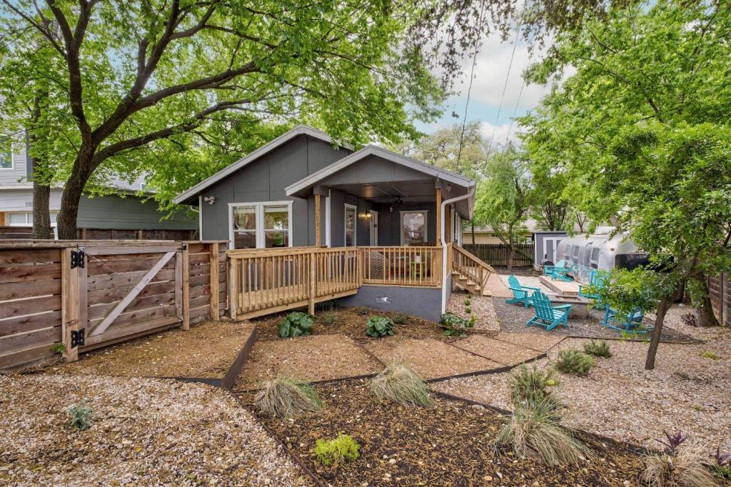 Casa pequeña con porche de madera y valla en Oak Grove Bungalow, en Austin