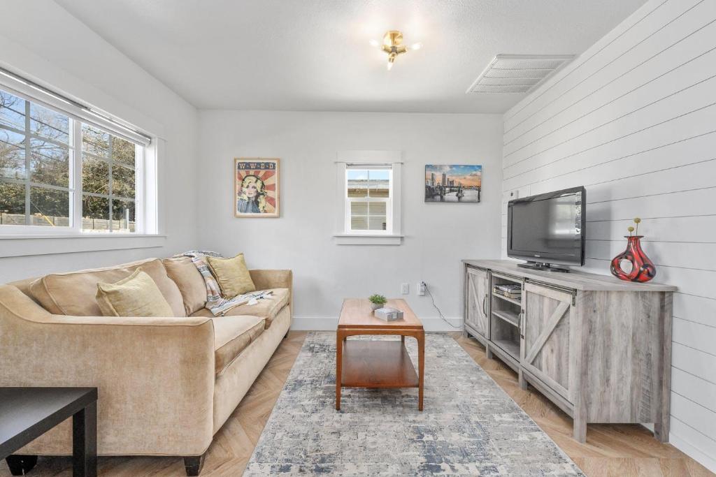 a living room with a couch and a tv at Canterbury Cottage in Austin