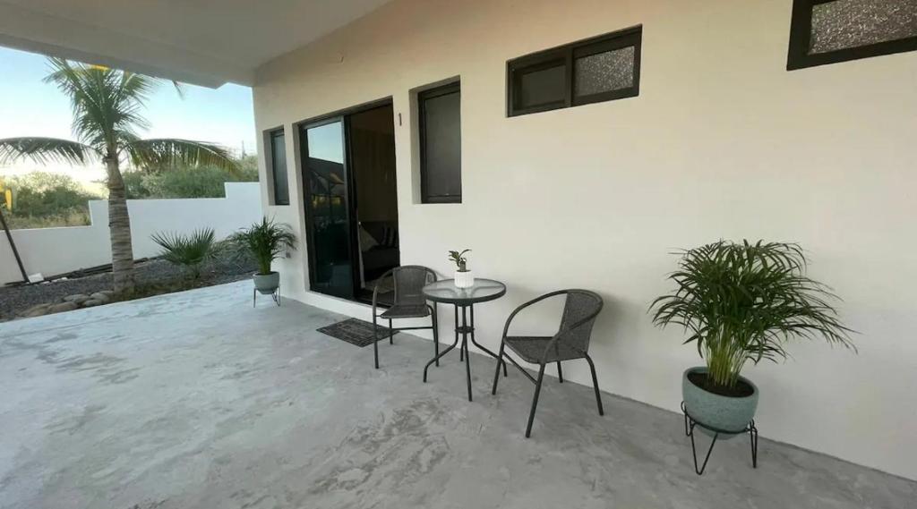 un patio con mesa, sillas y una planta en La Ventana Apartments Cactus 1, en La Ventana