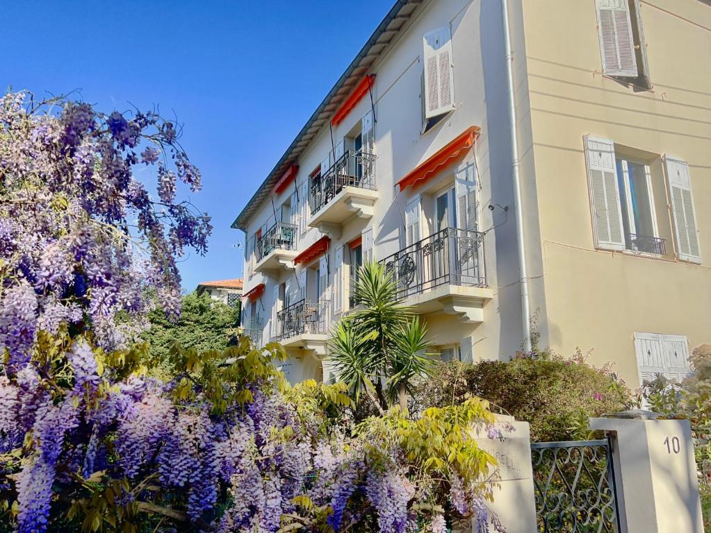 un bâtiment avec des fleurs violettes devant lui dans l'établissement Fiorella's Cannes Oasis, à Cannes