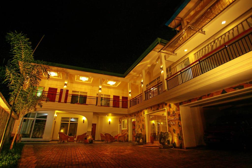 um grande edifício com um pátio à noite em Hotel Travellers Nest Kandy em Kandy