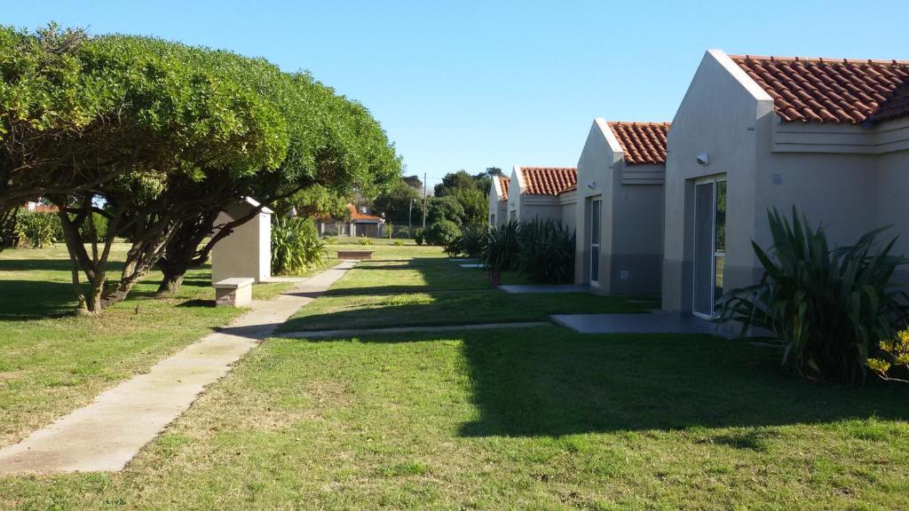 una fila de casas en un patio con árboles en Las Brusquitas Apart en Miramar