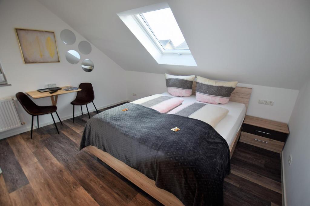1 dormitorio con 1 cama y escritorio con sillas en Ferienwohnungen Busch`s Gästehaus en Rust