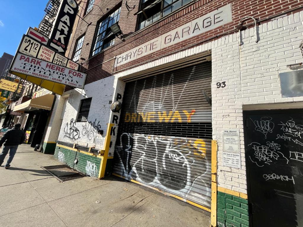 a store with a garage door with graffiti on it at moon lotus abode(月蓮居) in New York