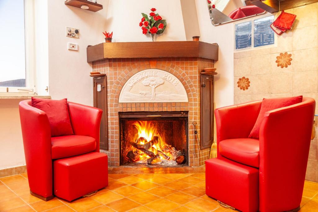 LaurinoにあるLa Terrazza di Laurinoの暖炉前の赤い椅子2脚