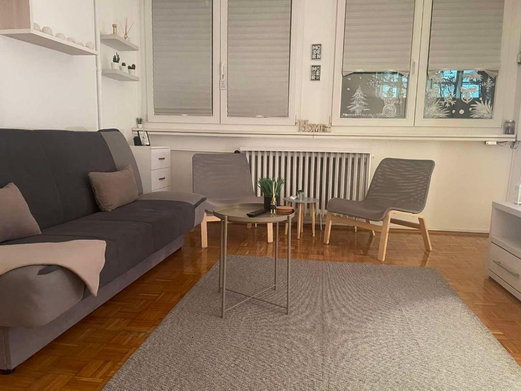 a living room with a couch and a table and chairs at Apartman Vuković in Novi Beograd