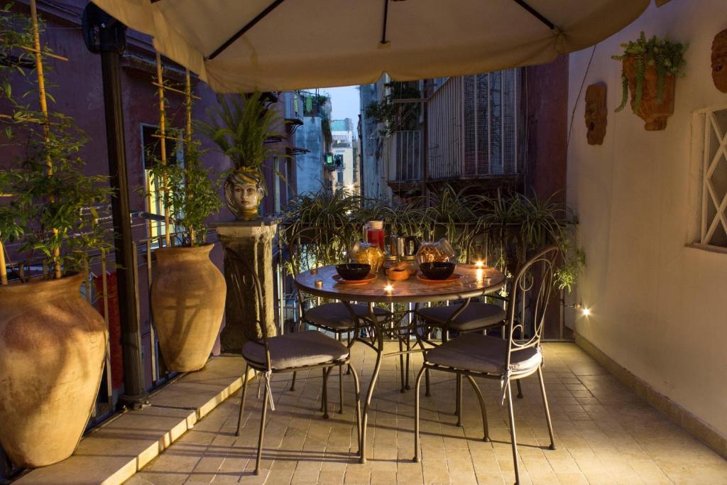 a table and chairs on a balcony with plants at Casa Latina in Naples