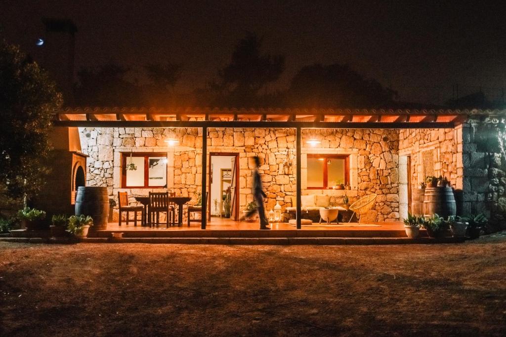 ein Steinhaus in der Nacht mit einer Person draußen in der Unterkunft Beautiful Olive's cave house in Lomo de Arico