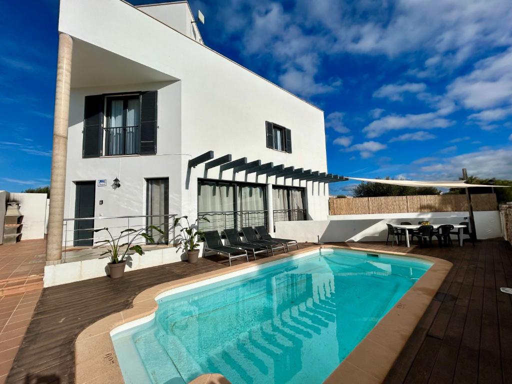 a villa with a swimming pool in front of a house at Villa Son Blanc 6 in Sa Caleta