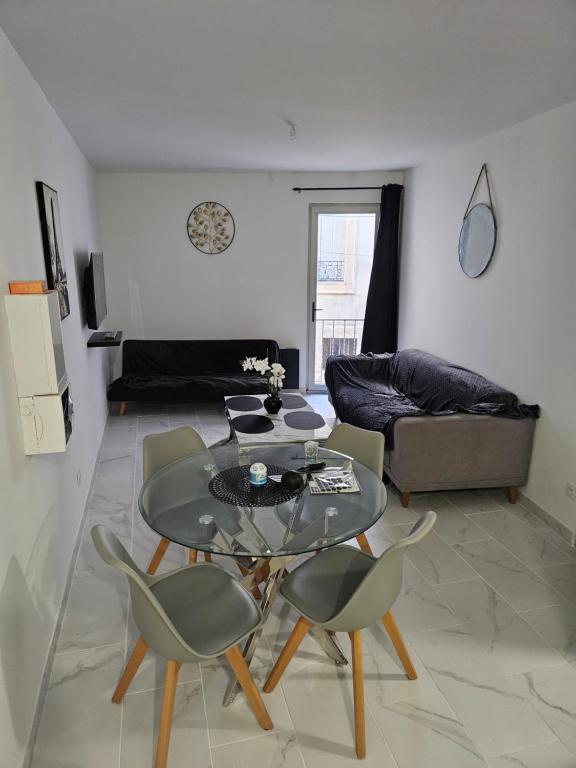 un salon avec une table en verre et des chaises dans l'établissement T2 moderne, calme et entièrement rénové., à Béziers
