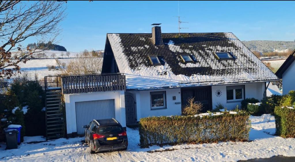 a car parked in front of a house in the snow at Mountainview villa in Wiemeringhausen