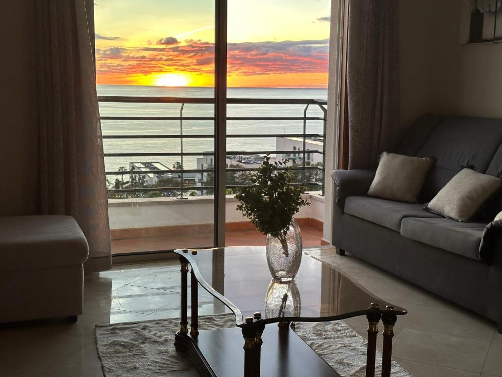 a living room with a couch and a vase on a table at Plaza near Forum Madeira in Funchal